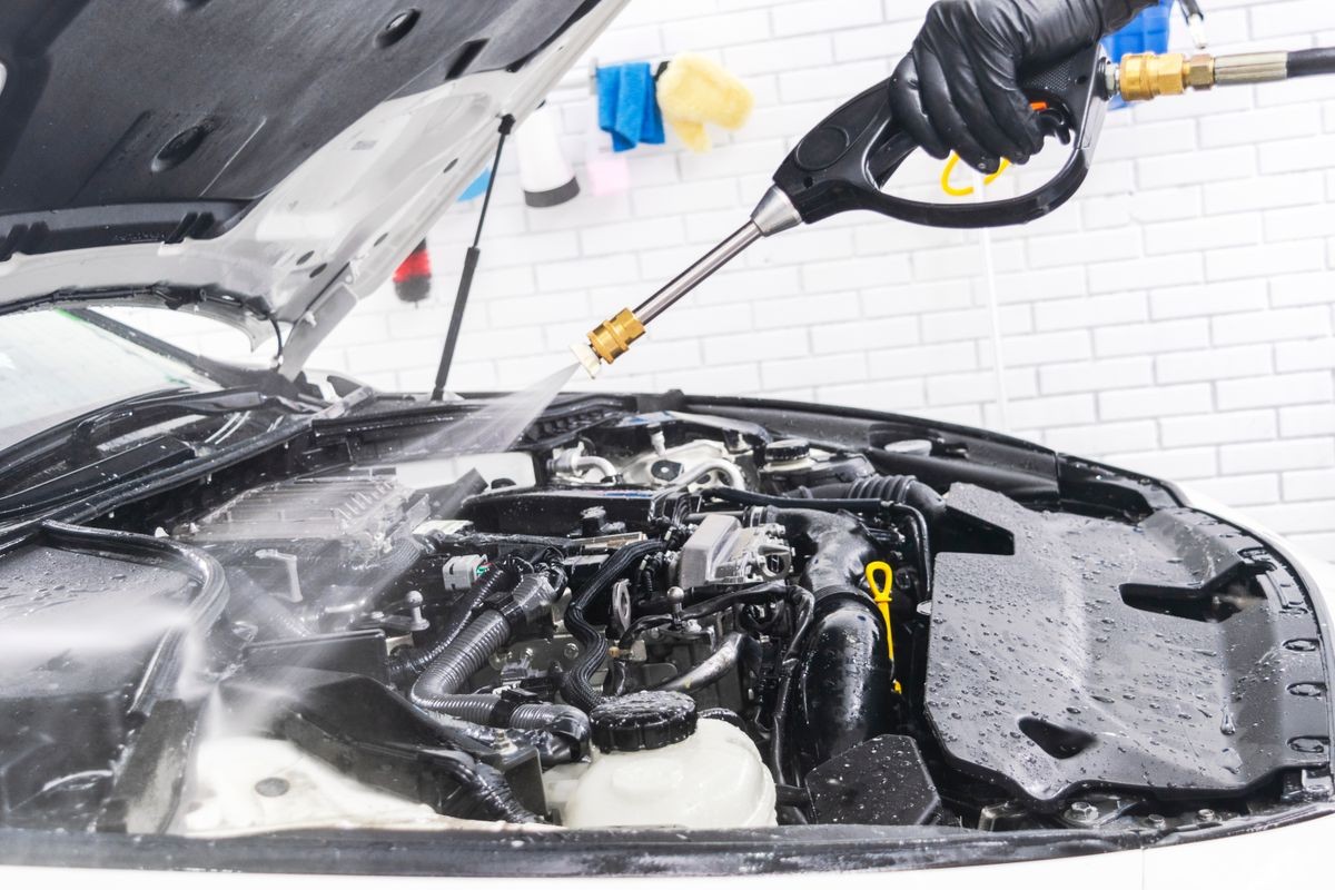 Car detailing. Manual car wash engine with pressure water. Washing car engine with water nozzle. Car cleaning. Man spraying pressure water for vehicle wash.